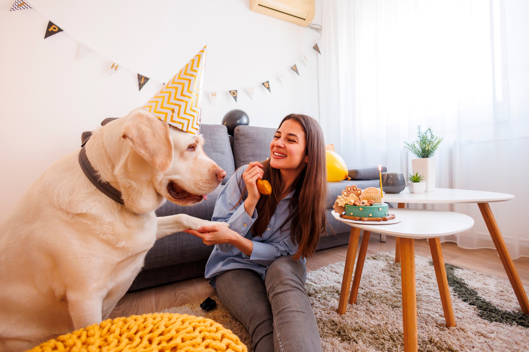 Woman blowing balloon at her dog birthday party